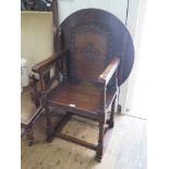 A carved oak Monk's chair, with circular back/top and turned legs