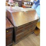 A George III mahogany and boxwood lined bureau, the sloping fall enclosing a stepped interior