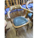 A 1920s beech office chair, the rail back over a padded seat on turned tapering legs joined by