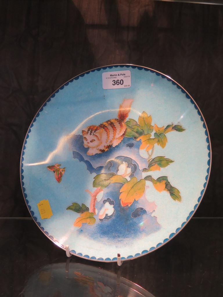 A vintage Chinese Cloisonne plate with a cat stalking a butterfly, 23cm diameter