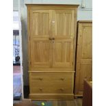 A light oak wardrobe, the twin panelled doors over two long drawers on a plinth base, 98.5cm wide