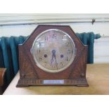 A 1930s oak mantel clock, of angular form with sunbursts and silvered dial, the twin train