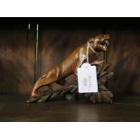 Chinese redwood hand carved tiger standing on a rocky outcrop with glass eyes, 13cm high