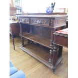 A late Victorian carved oak buffet, with two carved frieze drawers and fluted turned supports, 115cm