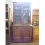 An Edwardian oak bookcase cabinet, the twin lead glazed doors enclosing adjustable shelves over a