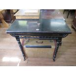 A Victorian Aesthetic Movement ebonised card table, the foldover top over a spindle turned frieze on