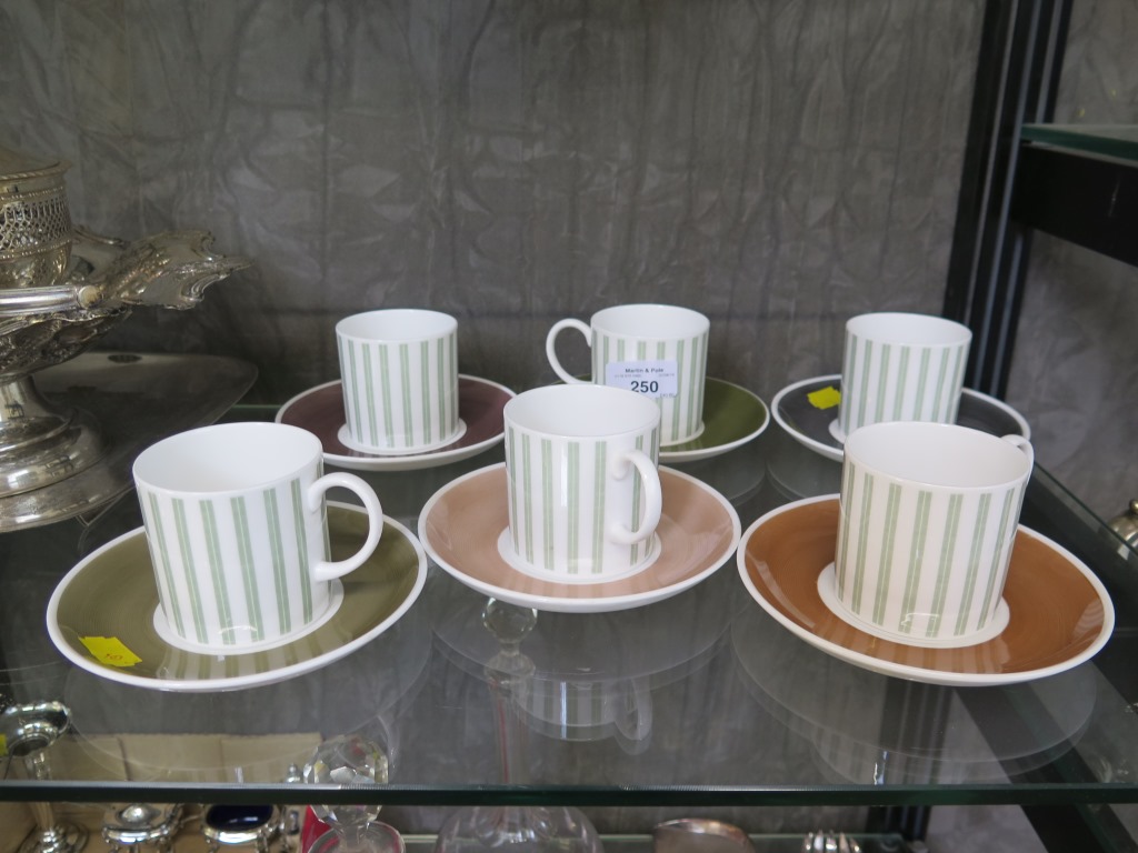 A set of six Susie Cooper coffee cans and saucers, with green bands to the cups, 7cm high