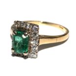 A fine trap cut ring, set with an emerald and diamonds