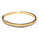 A 9 carat gold bangle decorated with Greek key pattern