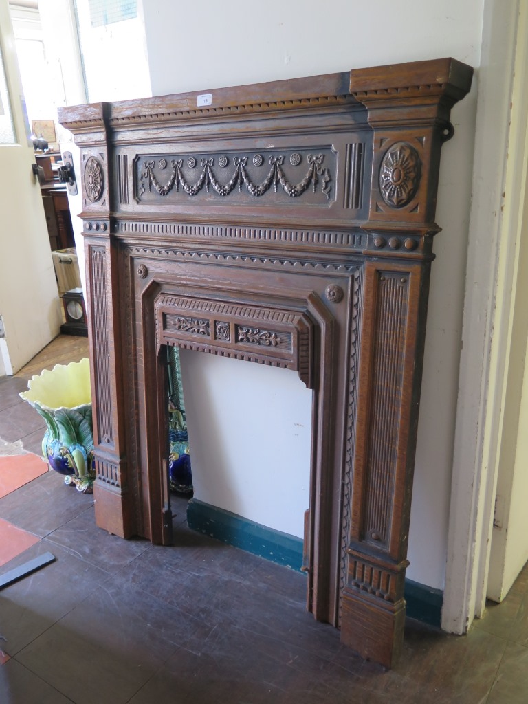 A late Victorian cast iron fire surround with swag and patera decoration, 108cm wide, 117cm high