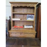 A French pine dresser and rack, carved with floral sprays, the rack with small drawers over a base
