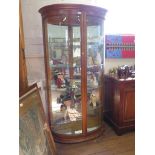 A walnut effect bowfront display cabinet, with bevelled glass and mirrored back, 103cm wide, 182cm
