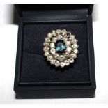 A large cluster ring with two rows of diamonds and a central sapphire set in 18 carat white gold (