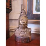 A Benin bronze bust of a figure in ceremonial dress, on a hardwood base 39cm high