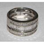 A diamond three row half eternity ring, set in 18 carat white gold, the centre row with baguette