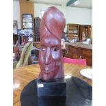 A carved hardwood mask sculpture labelled on the base 'The Work of Leslie H. Burley 1915-1968' in