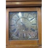A deal cased longcase clock, the cavetto moulded cornice over a brass dial, with mask spandrels,