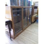 A walnut three door glazed display cabinet on a plinth base, by Heal's of London, label to one