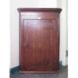 A 19th century corner cupboard, the cavetto cornice over a shell inlaid panelled door enclosing