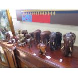 A collection of hardwood, brass or shell covered elephants, with turned wood or ivorine tusks,