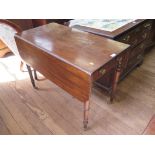 An early 19th century mahogany Pembroke table, the rectangular drop leaves over an ebony strung