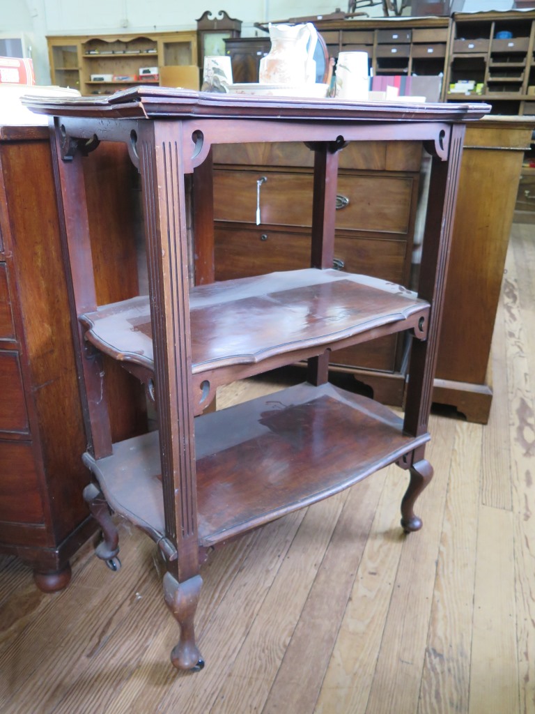 An Edwardian mahogany three tier whatnot with three shaped shelves on fluted supports and cabriole