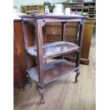 An Edwardian mahogany three tier whatnot with three shaped shelves on fluted supports and cabriole