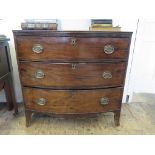 An early 19th century bowfront chest of drawers with three long drawers on outsplayed bracket