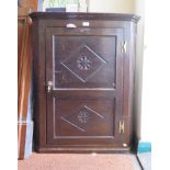 An oak corner cupboard, the twin panelled lozenge carved door enclosing straight shelves 75cm