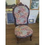 A mid Victorian rosewood nursing chair, the scroll carved upholstered back above a stuffover seat on