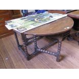 An 18th century oak gateleg table, the oval top over a foliate carved frieze and bobbin turned