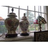 Two Oriental style ceramic table lamps on mahogany bases and a small Tiffany style table lamp with