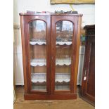 A Victorian mahogany bookcase, with twin glazed doors and adjustable shelves on a later plinth base,