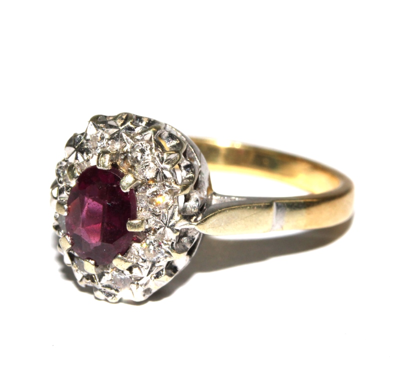 A ruby and diamond cluster ring set in 18 carat gold