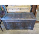 An 18th century oak coffer, the triple panelled lid over a lozenge and roundel carved front 129cm