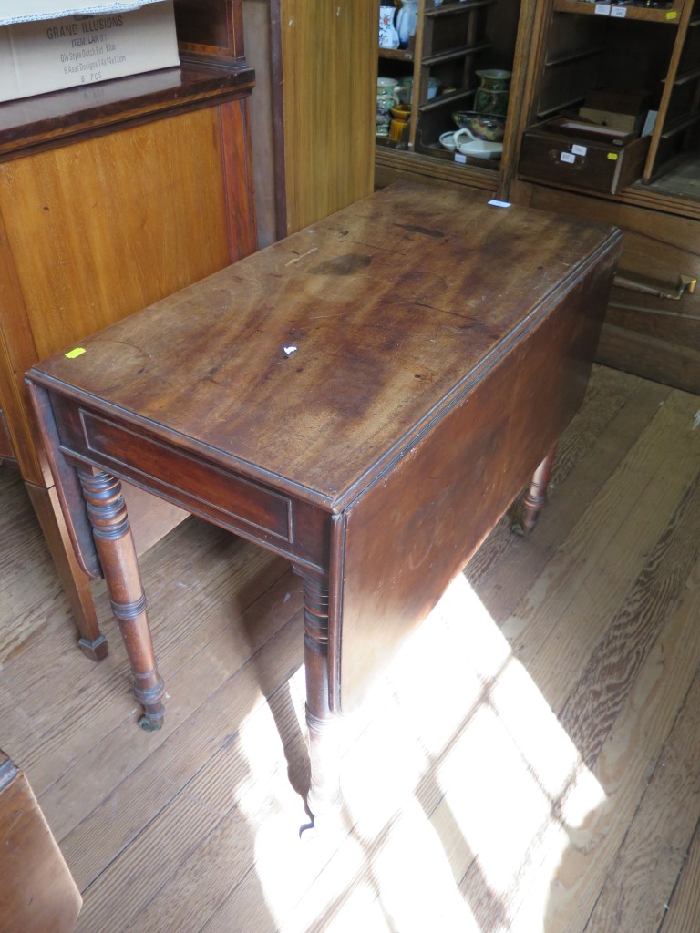 An early 19th century mahogany Pembroke table, the rectangular drop flaps over a frieze drawer on