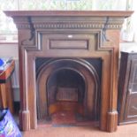 A late Victorian cast iron fire surround, with dentil and panelled frieze, 129.5cm wide, 134cm high,