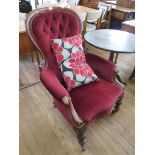 A Victorian mahogany buttonback gentleman's armchair, with scroll arms and turned tapering legs with