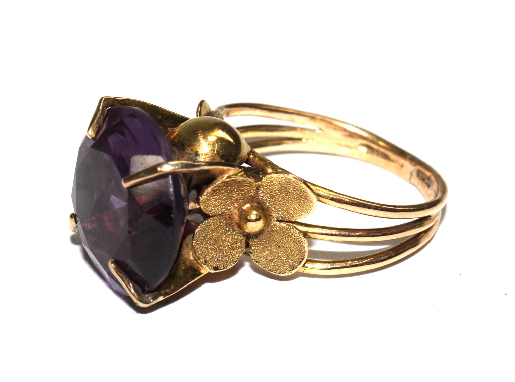 A gold ring set with a man made alexandrite