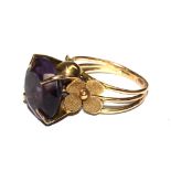 A gold ring set with a man made alexandrite