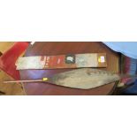 A 19th century painted paddle from the Pacific, depicting a rowing boat in a landscape 77cm long and