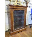A Victorian inlaid walnut display cabinet, the cavetto frieze over a glazed door with later glazed