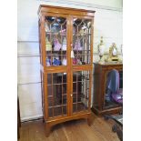 An Edwardian satnwood display cabinet, the diamond pattern inlaid frieze over a pair of glazed doors