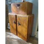 A 1930s burr walnut cocktail cabinet, by Rivington of London, the rising top enclosing a mirrored