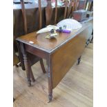 A Victorian mahogany Pembroke table, the rectangular drop leaf top on ring turned tapering legs