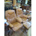 A pair of leatherette easy armchairs on outsplayed swivel bases and a footstool (3)