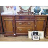 An Edwardian inverted breakfront sideboard, with frieze drawer over two graduated drawers flanked by