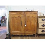 A 19th century French pine cabinet, with two frieze drawers over a pair of panelled doors on