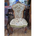 A Victorian walnut nursing chair, the carved crest over a waisted tapestry back and seat on