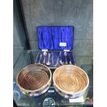 A pair of plated coasters and a set of silver coffee spoons